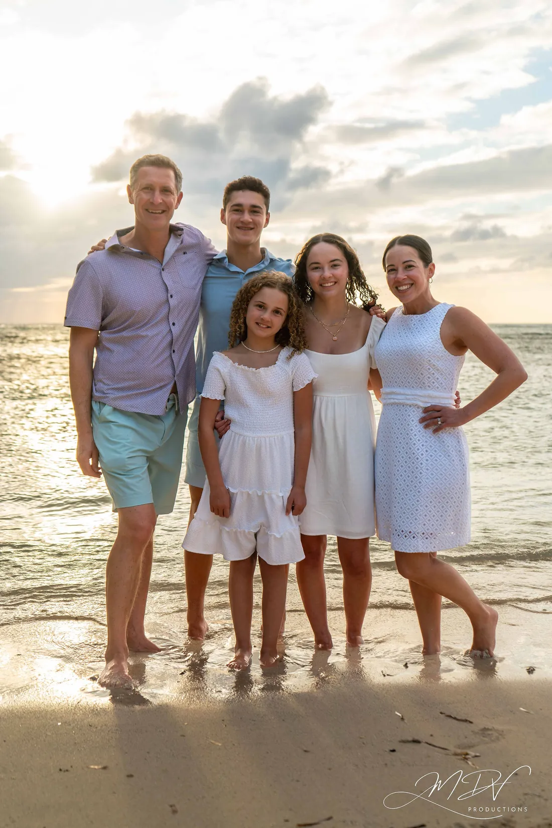 Family of five in white on the beach at dusk in Aruba